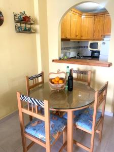 a kitchen with a table and chairs with a bowl of oranges at ApartalMar in Torrevieja +4 photos