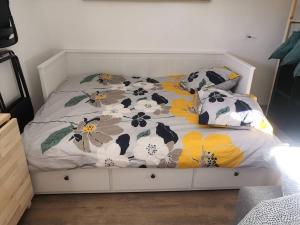 - un lit avec une couette et des oreillers en fleurs dans l'établissement Le studio lamottois, à Lamotte-Beuvron