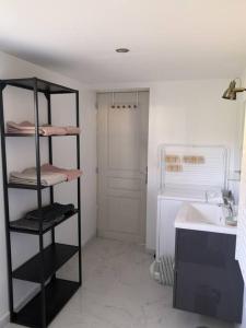 Un baño con una estantería negra junto a un lavabo. en Le studio lamottois, en Lamotte-Beuvron