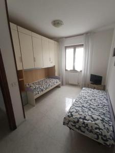 a bedroom with two beds and a window at il viandante, anima toscana in Vicarello