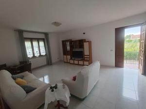 a living room with two white couches and a television at il viandante, anima toscana in Vicarello