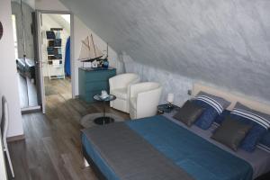 a bedroom with a blue bed and a chair at MOR-HA-MARCH Chambres d'Hôtes in Sarzeau