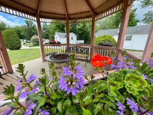 a wooden pergola with purple flowers on a deck at Merrill Farm Inn in North Conway