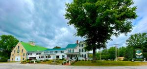 a large white house with a green roof at Merrill Farm Inn in North Conway