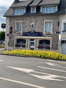 un bâtiment situé dans une rue avec des fleurs devant elle dans l'établissement Hotel & Restaurant Hanoï Station, à Saint-Malo