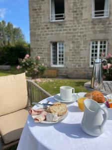 einen Tisch mit einem Teller Essen und Kaffee darauf in der Unterkunft La Maison Gervaiserie & Spa in Réville