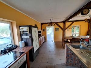 a kitchen with a refrigerator and a table in it at Śródziemie Gondor in Leśno