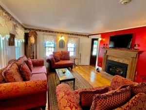 a living room with red walls and a fireplace at Merrill Farm Inn in North Conway