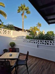 eine Terrasse mit einem Tisch, Stühlen und Palmen in der Unterkunft Apartamento Los Marinos in Tías + 31 Fotos