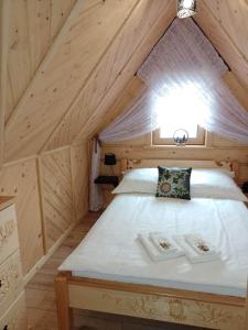 ein Schlafzimmer mit einem Bett im Dachgeschoss in der Unterkunft Domek Na Góralską Mode in Suche