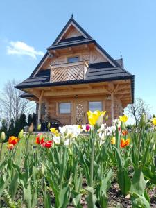 ein Blockhaus mit Blumen davor in der Unterkunft Domek Na Góralską Mode in Suche