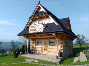 a log cabin with a black roof at Domek Na Góralską Mode in Suche