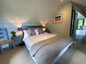 ein Schlafzimmer mit einem großen Bett und einem Stuhl in der Unterkunft Downton Lodge Country Bed and Breakfast and; Self Catering in Dartmouth