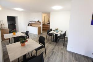 a dining room with tables and chairs and a kitchen at Affittacamere Mercedes in Romallo