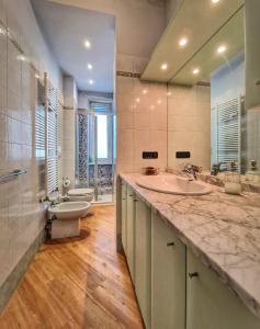een badkamer met 2 wastafels, een toilet en een spiegel bij Ana's Place Torino 3 in Turijn