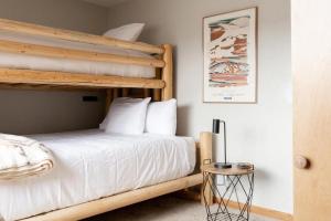 a bedroom with two bunk beds and a table at Mod MTN Must - Steps from Shuttle - Silverthorne in Silverthorne