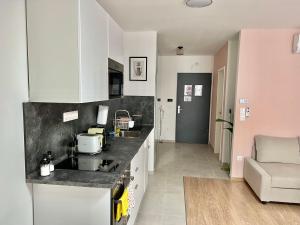 cocina con armarios blancos y encimera en MM D Home Apartment, en Budapest