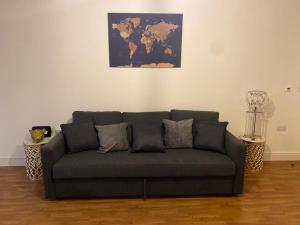 a couch in a living room with a map on the wall at Streatham high street in London