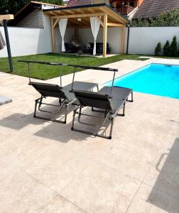 two chairs and a table next to a swimming pool at Ubytování Na Jarošce in Hodonín