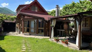 ein Holzhaus mit einer Veranda und einem Hof in der Unterkunft Casa veche “Old house” in Sibiel