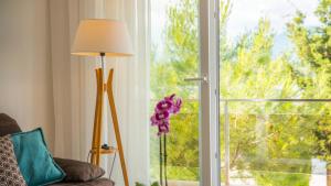 a room with a window with a lamp and a couch at Apartments Edera in Tivat