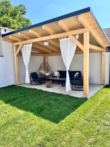 drewniana pergola z dwoma niebieskimi kanapami na patio w obiekcie Ubytování Na Jarošce w mieście Hodonín