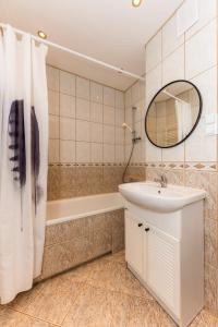 a bathroom with a sink and a tub and a mirror at Przystań Nemo in Ustka