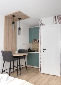 eine Küche und ein Esszimmer mit einem Tisch und einer Tür in der Unterkunft Apartments HAN 2 Sarajevo in Sarajevo