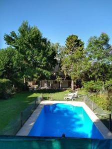 a large blue swimming pool in a yard at Casa amplia - Pileta y parque in Bella Vista