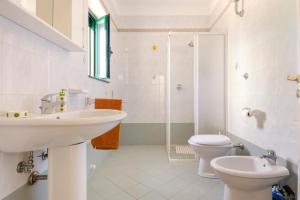 uma casa de banho com um lavatório, um WC e um chuveiro em Villa Laura em Carovigno