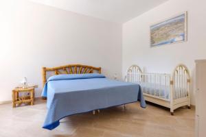 カロヴィーニョにあるVilla Lauraのベッドルーム(青いベッド1台、ベビーベッド1台付)