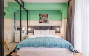 Devdaraki Apartments في كازباجي: غرفة نوم بسرير كبير وبجدار اخضر