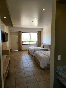 a hotel room with two beds and a window at Hotel Paraiso Las Palmas in Ensenada