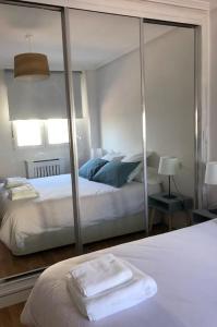 サリナスにあるA Estrenar. Apartamento Reformado con vistas.のベッドルーム(大きな鏡、ベッド付)