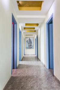 a hallway with blue doors and a painting on the wall at Hotel Assini Beach Tolo in Tolo