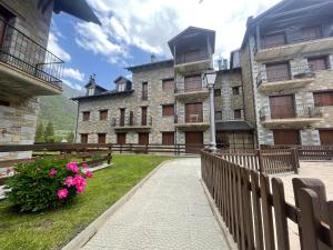 un edificio con una valla y flores delante de él en L11 - Bajo con jardín en Linsoles - Villmor, en Anciles