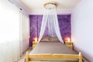 a bedroom with a bed with a mosquito net at Hotel Assini Beach Tolo in Tolo