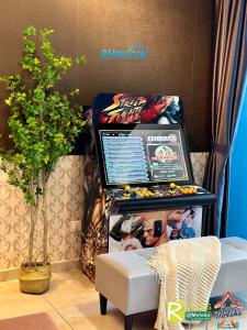 a pinball machine in a room with a chair at Atlantis Residences Melaka by HeyStay Management in Melaka +275 photos