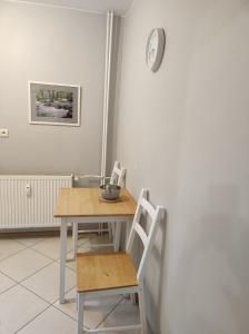 una mesa con dos sillas y un reloj en la pared en Apartament Natura en Mrągowo