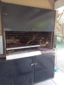 einen schwarzen Ofen mit einem Feuer darin. in der Unterkunft Casa amplia - Pileta y parque in Bella Vista