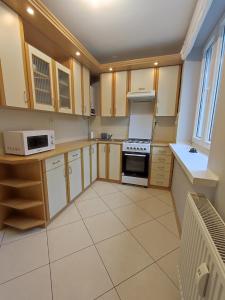 una cocina con electrodomésticos blancos y armarios de madera en Apartament Natura en Mrągowo