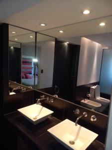 a bathroom with two sinks and a large mirror at Casa amplia - Pileta y parque in Bella Vista