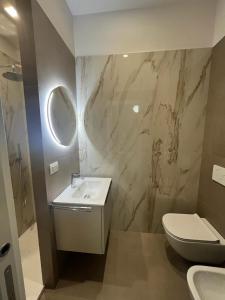 a bathroom with a sink and a toilet and a mirror at URBAN SUITE in Bari