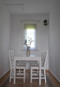 a white dining room table with chairs and a vase with flowers at Chalet en Suances in Ongayo +7 photos