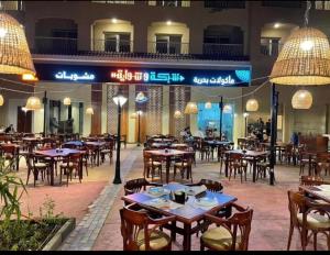 un restaurant vide avec des tables, des chaises et des lumières dans l'établissement Aqua View north coast for Egyptians only, à El Alamein