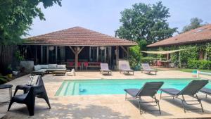 a swimming pool with chairs and a house at Maison Pimoli : Chambre Hortense in Soustons +7 photos