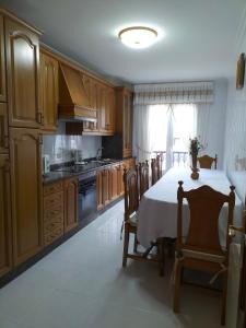 a kitchen with a table and chairs and a kitchen with at O NOSO FOGAR in Melide