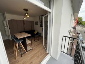 een kamer met een balkon met een tafel en een bank bij STUDIO JULES VERNE - HYPER CENTRE LORIENT in Lorient
