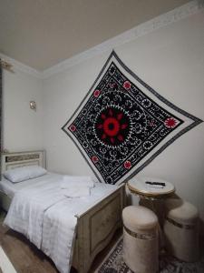 een deken aan de muur van een slaapkamer bij Qozi Hotel in Samarkand