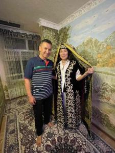 een man en een vrouw die voor een schilderij staan bij Qozi Hotel in Samarkand